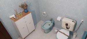 Un baño con un inodoro azul y un lavabo. en SwordFish Cliff Apartment, en Peniche