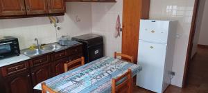 Una pequeña cocina con una mesa y un refrigerador blanco. en SwordFish Cliff Apartment, en Peniche 4 fotos más