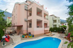 an apartment with a swimming pool in front of a building at Apartments Bojka in Promajna