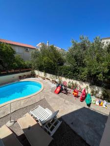 a swimming pool with lounge chairs and a swimming pool at Apartments Bojka in Promajna