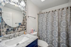 a bathroom with a sink and a toilet and a mirror at Herons Rest -- Riverfront, Fire Pit, All seasons Porch, Grill, Games, Fishing, Deck, Wifi, River view in Great Cacapon +94 photos