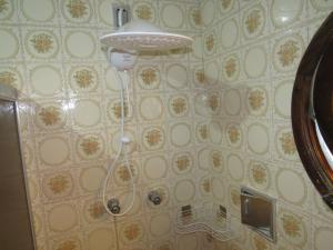 a bathroom with a shower head hanging from a wall at Quarto Suíte Pitanga in Atibaia +17 photos