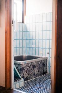 a bathroom with a tub in a blue tiled room at Japanese Local House - 奥葉山の一棟貸しの隠れ家宿 - 静かな縁側と和室 in Hayama