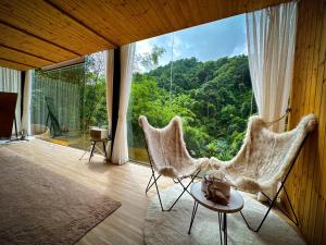 a room with two chairs and a large window at Morning Star Glamping in Ban Pok Nai