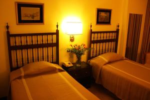 1 dormitorio con 2 camas, lámpara y teléfono en Hotel Vice-Rei, en Oporto