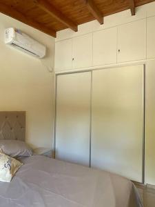 1 dormitorio con armarios blancos y 1 cama con almohada en Casareartesesok, en Los Reartes 15 fotos más
