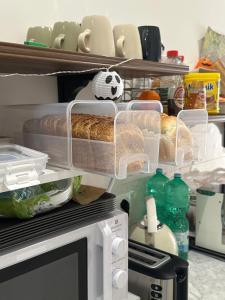 una cucina con forno a microonde, pane e bottiglie di The HeArt Guest House a Napoli