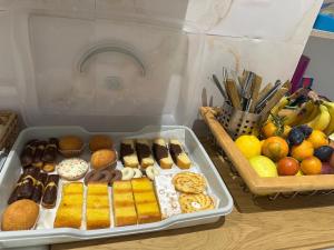 un contenitore in plastica riempito con diversi tipi di ciambelle e frutta di The HeArt Guest House a Napoli