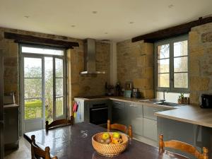 a kitchen with a table with a basket of fruit on it at Proche de SARLAT -Vue exceptionnelle in Carlux