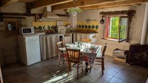 a kitchen with a table with chairs and a refrigerator at Entire Gite in Espeyrac 'Le Clapadou' in Espeyrac