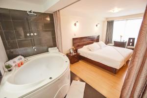 a bathroom with a bath tub and a bed at Inti Tampu Inn in Cusco +78 photos