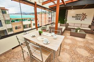 a wooden table and chairs on a balcony at Inti Tampu Inn in Cusco