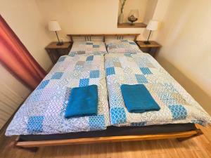 un letto con cuscini blu sopra di APARTMÁN u SJEZDOVKY a Albrechtice
