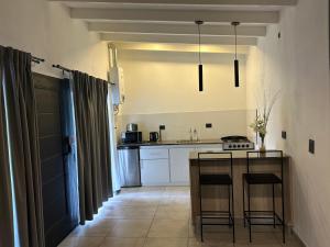 eine Küche mit einem Tisch und einem Herd in der Unterkunft cabañas La Amelia Premium con piscina privada 2 personas in Mina Clavero