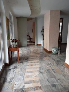 an empty room with a stone floor and a table at Miramonti Hotel Saint Vincent in Saint Vincent