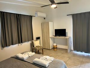 ein Schlafzimmer mit einem Bett und einem Schreibtisch mit einem Computer in der Unterkunft cabañas La Amelia Premium con piscina privada 2 personas in Mina Clavero