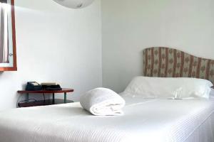 a white bed with a towel on top of it at Miramonti Hotel Saint Vincent in Saint Vincent