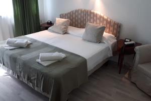 a bedroom with a large bed and a chair at Miramonti Hotel Saint Vincent in Saint Vincent