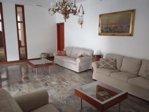 a living room with couches and a chandelier at Miramonti Hotel Saint Vincent in Saint Vincent