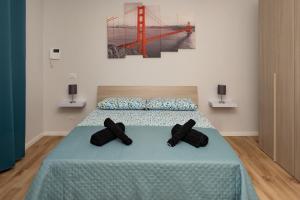 a bedroom with a bed with two black pillows at Fix You Apartment Fco 2 in Fiumicino