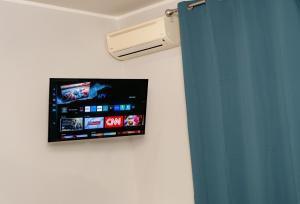 a flat screen tv hanging on a wall at Fix You Apartment Fco 2 in Fiumicino