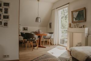 a dining room with a table and chairs and a window at Weissewolke in Bad Fallingbostel