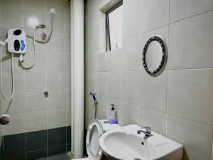 une salle de bain avec un lavabo, des toilettes et un miroir dans l'établissement Ammara Homestay Emerald Avenue Cameron Highlands, à Brinchang 15 autres photos