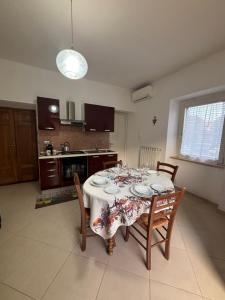 a dining room table with chairs and a white table cloth at L'alloggio turistico di Zoe in Tuscania +16 photos