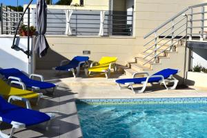 a pool with blue and yellow chairs next to a building at Casa da Vitoria in Falca