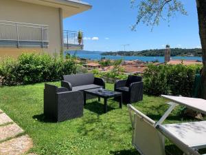 un patio con 2 sillas y una mesa en el césped en Attico Ai Colli, en Saló