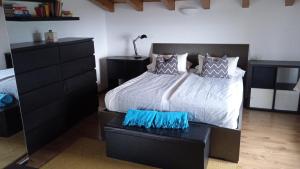 Un dormitorio con una cama grande y una cómoda. en Attico Ai Colli, en Saló