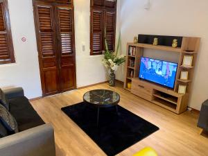 a living room with a couch and a tv at LOFT T2 en couleur en plein centre ville Fort-De-France Martinique in Fort-de-France