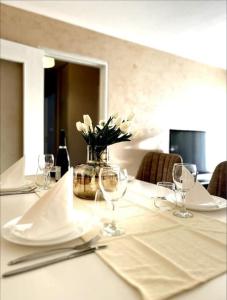a table with wine glasses and a vase of flowers at Appartement à 10 min de Strasbourg in Strasbourg