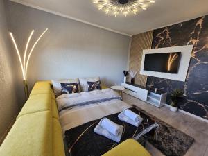 a bedroom with a bed and a couch and a tv at Apartmani Višnja in Crikvenica