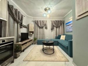 a living room with a blue couch and a table at City Palm Retreat in Mytilini
