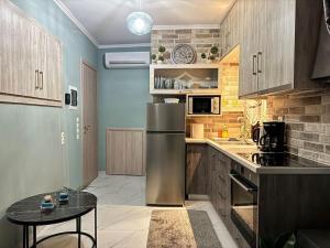 a kitchen with a stainless steel refrigerator and a table at City Palm Retreat in Mytilini