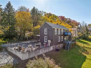 een klein huis met een terras in de tuin bij Historic William Smith House -- Pet Friendly, Grill, Wifi, Fire Pit, Deck, Family Friendly, Town Location, King Bed, Creekside in Berkeley Springs