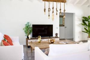 Una sala de estar con una mesa y un televisor. en Villa Serenity, en Cul de Sac