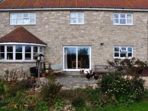 韦茅斯Jurassic Loft Apartment的一栋砖房，门前有两只鸡。