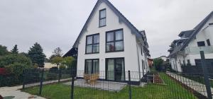 a white house with a gambrel roof at Moderne Doppelhaushälften - Rose Garden 1 & 2 - 17 km vom Frankfurter Flughafen und 30 km vom Messegelände entfernt in Offenbach