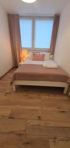 a bedroom with a large bed with a large window at Apartament Roanta in Polanica-Zdrój