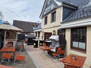 a patio with tables and chairs outside of a building at Schlaffass auf Stellplatz am Elbkrug 2 0 in Büttel