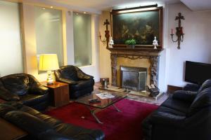 uma sala de estar com sofás de couro e uma lareira em Hotel Vice-Rei no Porto