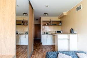 a room with a kitchen with white cabinets at Studio Apartment in Kaunas +9 photos