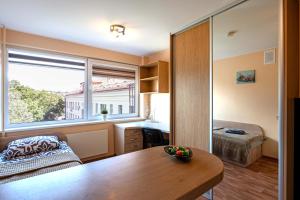 a room with a table and a bed and a window at Studio Apartment in Kaunas