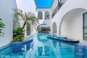 a swimming pool in a house with a surfboard in it at Shark Villa 160 - Đi Bộ Ra Cột Cờ Bãi Sau Thùy Vân - Free Bida - Loa Karaoke in Vung Tau