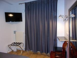 a room with a blue curtain and a table and a chair at Hôtel de Lorraine in Paris +17 photos