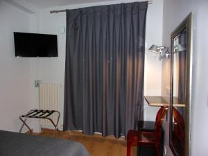 a bedroom with a window with a gray curtain at Hôtel de Lorraine in Paris