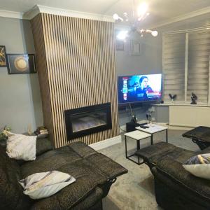 un soggiorno con camino e TV di Aldwych house, For Holidays, Contractors & Relocation, Free Parking & Wi-Fi a Preston