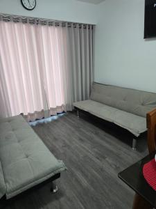 a living room with two couches and a clock at SAM Apartment Cusco in Cusco